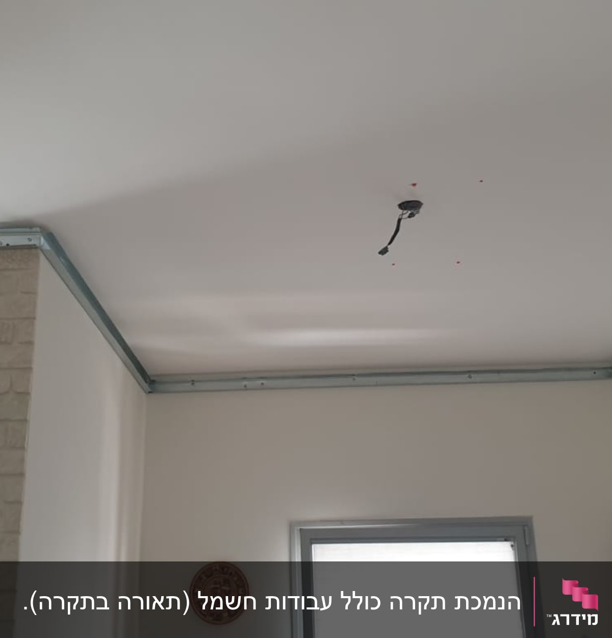 עובד מתקין לוחות גבס בתקרה עם מסגרת מתכת